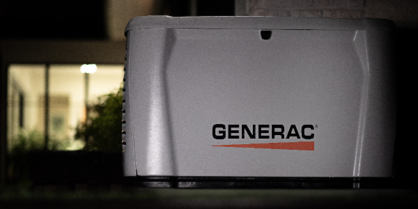 Close-up of a Generac generator unit in a dimly lit setting.