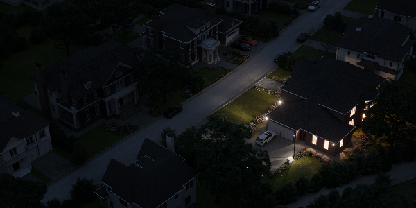 Nighttime neighborhood street illuminated by streetlights and porch lights.