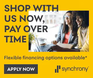Two people sit together using a laptop. Text reads "Shop with us now, pay over time. Flexible financing options available." There is an "Apply Now" button with the Synchrony logo.