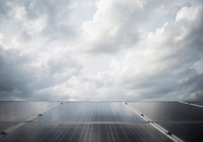 Solar panels beneath a cloudy sky.