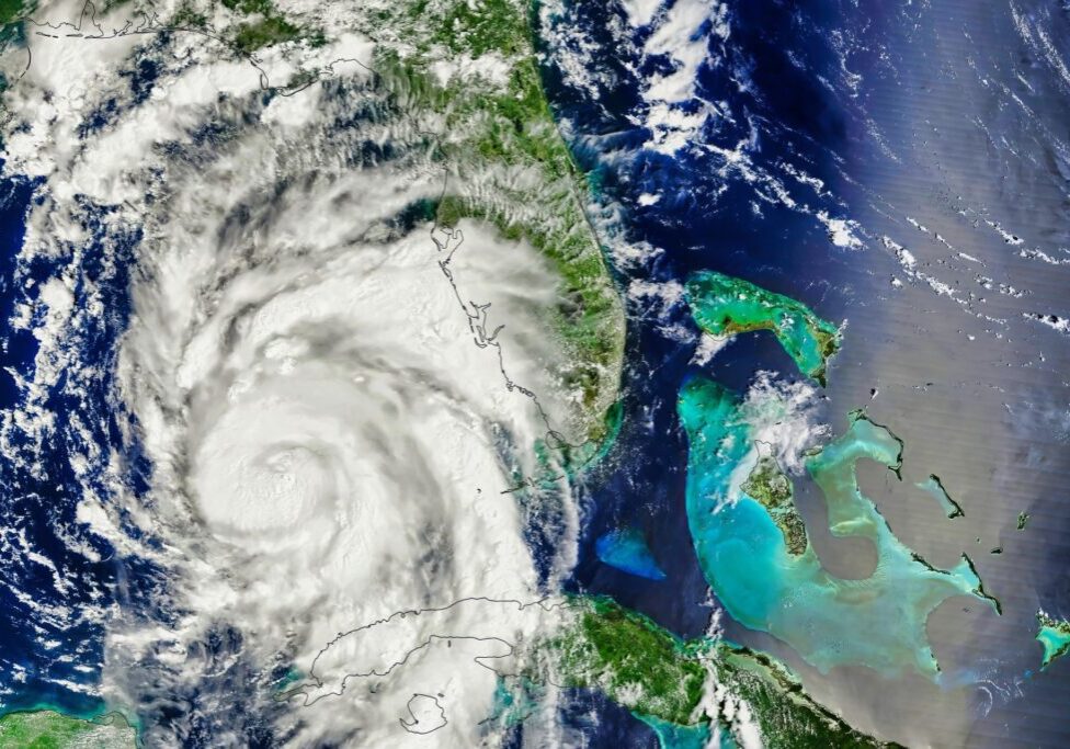Satellite image of a swirling hurricane approaching Florida, with visible cloud formations extending across the state and surrounding ocean.